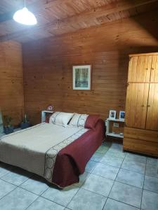a bedroom with a bed and a wooden wall at La casa de MaCa in Posadas +16 photos