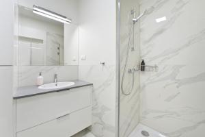 Un baño blanco con ducha y lavabo. en YOURAPART Piwna Luxury Apartment, en Gdansk 40 fotos más