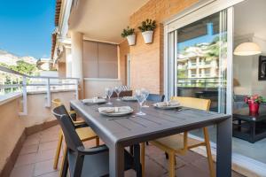 a dining room with a table and chairs on a balcony at Seaside stay with large terrace, pool & parking REMS in Benalmádena