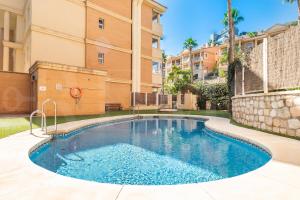 a swimming pool in front of a building at Seaside stay with large terrace, pool & parking REMS in Benalmádena