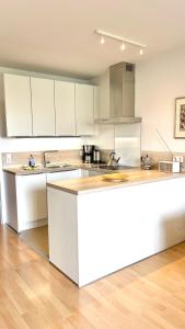 ランゲオークにある'Accumer Ee'の白いキャビネットと白いカウンタートップを備えたキッチン +2枚の写真