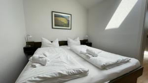 ランゲオークにある'Accumer Ee'の白いシーツが敷かれたベッドが2つある寝室