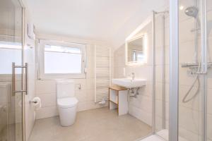 a bathroom with a toilet and a sink and a window at Ferienhaus DÖRING in Langeoog +13 photos