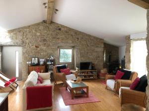 a living room filled with furniture and a stone wall at Casa do Couço in Sever do Vouga