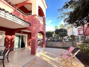 a patio of a house with chairs and tables at Planta baja con gran terraza y jardín Altaona golf in Murcia