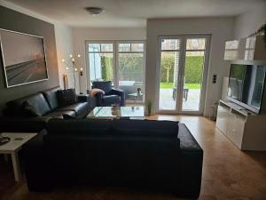 a living room with a couch and a tv at Mucki´s Ferienwohnung in Bad Zwischenahn