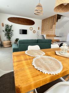 comedor con mesa de madera y sofá verde en CORRALEJO SURF HOUSE & SURF SCHOOl, en Corralejo