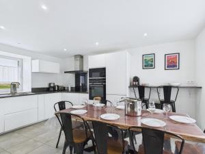 a kitchen with a wooden table and chairs in a room at Maison de campagne avec grand jardin pour 8 in Plouguerneau