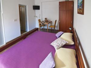 a bedroom with a large bed with purple sheets at Villa Era in Dubrovnik