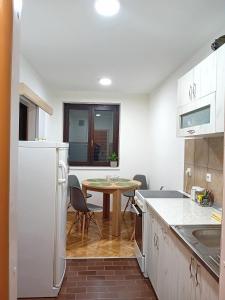 a kitchen with a table and a small table and chairs at Apartman Tanja in Arandelovac +9 photos
