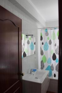 een badkamer met een wastafel en een douchegordijn bij Baleal Holiday Apartment in Baleal +12 foto's