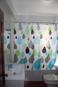 een badkamer met een douchegordijn, een toilet en een wastafel bij Baleal Holiday Apartment in Baleal