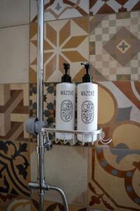 two bottles of mascara sitting on a shelf in a bathroom at Vavana Studios in Symi