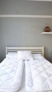 a white bed with white sheets and pillows at Wanha Rovastiinna, SELF-SERVICE Unique city apartment in Vaasa +5 photos
