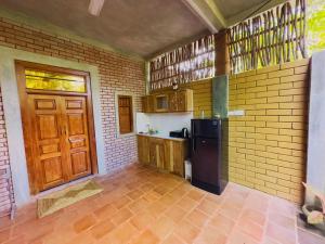 a kitchen with a black refrigerator and a brown door at Onara Home Koggala in Habaraduwa Central