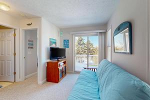 a living room with a blue couch and a tv at Northern Michigan Manistee Magic in Manistee