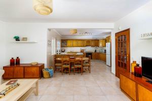 a kitchen and dining room with a table and chairs at Villa Audiência 38 in Monte Gordo