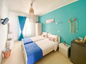 a blue bedroom with a bed and a blue wall at Beachfront Alonissos Rooms - Galazia Thea Gems in Alonnisos