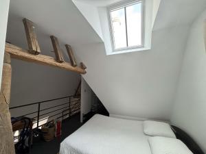 una piccola camera da letto con un letto e una finestra di Résidence du Palais a Bourges