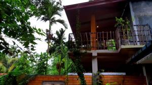 a house with a balcony on the side of it at Onara Home Koggala in Habaraduwa