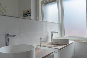 a white bathroom with a sink and a mirror at Casa Del Mare 50 m dal mare - nuova - Pasqua in Maremma in Castiglione della Pescaia +14 photos