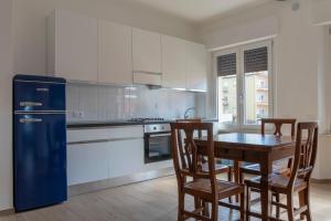 a kitchen with a table and chairs and a refrigerator at Casa Del Mare 50 m dal mare - nuova - Pasqua in Maremma in Castiglione della Pescaia