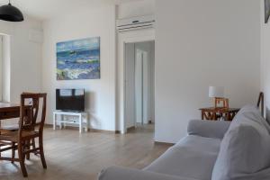 a living room with a couch and a table and a tv at Casa Del Mare 50 m dal mare - nuova - Pasqua in Maremma in Castiglione della Pescaia