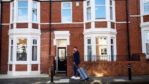 a man standing in front of a brick building at West Beck House - Newcastle 6 in North Shields
