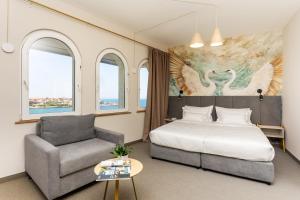 a bedroom with a bed and a couch and a chair at Hotel Antea - By The Sea in Sozopol +85 photos