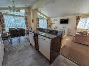 a kitchen and living room with a couch and a table at Luxury 6 Berth Lodge With Wifi At Broadland Sands In Suffolk Ref 20011Cv in Hopton on Sea