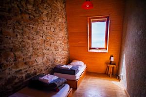 a room with two beds and a brick wall at Village de vacances Le Serre de la Can in Saint-Germain-de-Calberte
