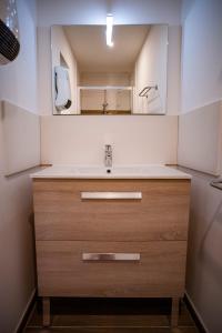a bathroom with a sink and a mirror at Village de vacances Le Serre de la Can in Saint-Germain-de-Calberte