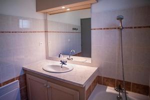 a bathroom with a sink and a shower with a mirror at Village de vacances Le Serre de la Can in Saint-Germain-de-Calberte +16 photos