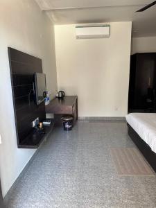 a bedroom with a bed and a desk and a tv at Amazing Fun World By Nexottel in Dwarka