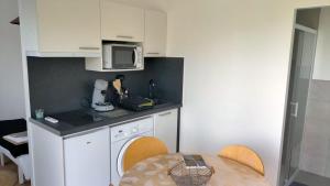 a small kitchen with a table and a microwave at O repère du loup in Ségus