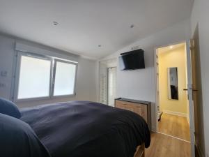 une chambre avec un lit et une télévision à écran plat dans l'établissement Le Loft Minimaliste, à Savigny-sur-Orge