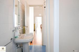 a bathroom with a sink and a mirror and a hallway at Inn Pisa Rentals 2 - Sunny Corner Pisa Flat in Pisa +65 photos