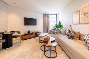 a living room with a couch and a table at Studio Ferme Bretonne, Bien Desservi & Salle Gym in LʼOasis