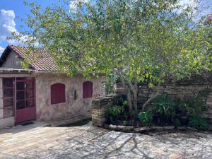 una casa con un albero accanto a un muro di mattoni di Pousada Morada do Soberano a São Thomé das Letras