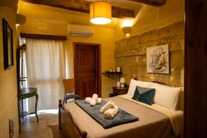 a bedroom with a bed with two stuffed animals on it at Il figolla b&b in Xagħra +37 photos