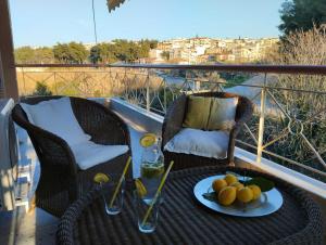 a table with a plate of fruit on a balcony at summer time in Neoi Epivates