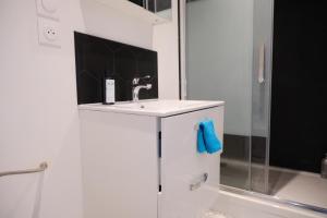 a white bathroom with a sink and a shower at Your Home Loos 2 - Proche Lille in Loos