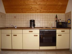 a kitchen with white cabinets and a black oven at Wohnung mit Balkon im Schwarzwald in Seebach