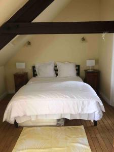 莫龙Bakers Cottage near broceliande forest的卧室里有一张白色的大床，床边还有两盏灯