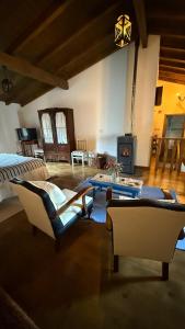 a living room with a bed and chairs and a table at LouzaNook - Casa do Moinho in Lousã