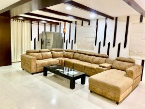 a living room with a couch and a coffee table at Cozycasa By Nattis group 4 BR - Jacuzzi & private garden in Kondapur +37 photos
