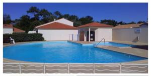 a large blue swimming pool in front of a house at Duplex Brem Sur Mer Piscine Proximité Plage Parking 5 pers Max in Brem-sur-Mer