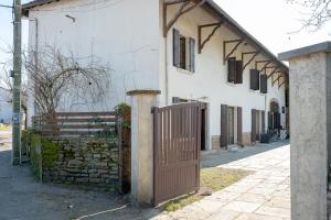 une porte en bois devant un bâtiment blanc dans l'établissement Kali-Milo, à Saint-Romain-de-Jalionas