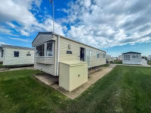a tiny house sitting on top of a yard at Homely Caravan With Free Wifi At Broadland Sands Park, Suffolk Ref 20002Bs in Hopton on Sea