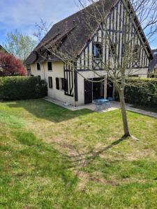 a house with a tree in front of it at Maison paisible avec jardin à Houlgate in Houlgate